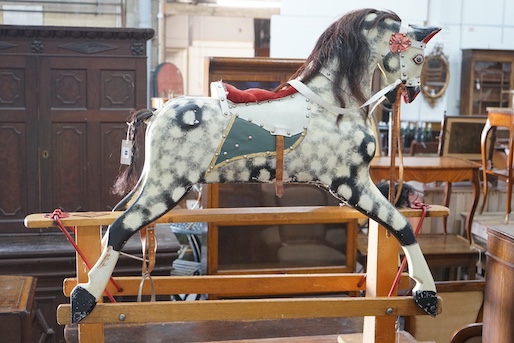 A vintage Ayres type dapple grey carved wood rocking horse on beech safety frame, length 130cm, height 115cm